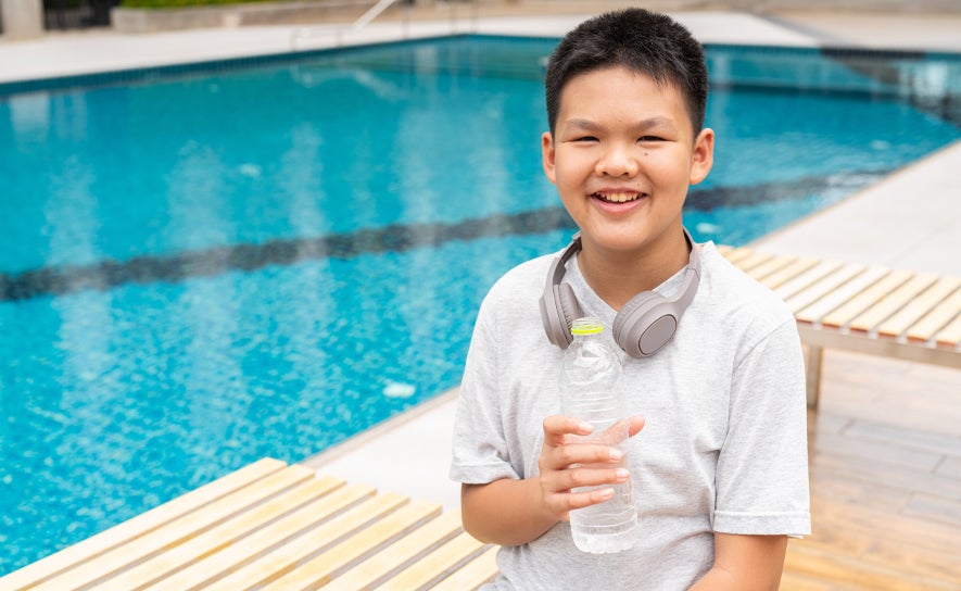 Boy with Water Bottle by Pool